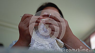 Een bejaarde vrouw in aziatische vrouwen zit in het huis met breiwerk in een hobby die delicaat vakmanschap is. stock footage Een bejaarde vrouw in aziatische vrouwen zit in het huis met breiwerk in een hobby die delicaat vakmanschap is. stock footage