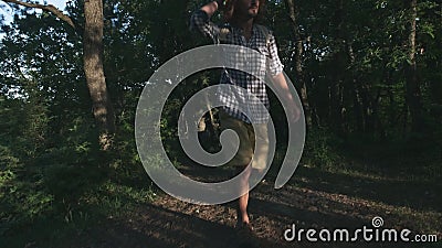 Een jonge boer die in het hout lopen Wandelaar die in bos bij zonsondergang wandelen Actieve levensstijl Het dragen van een gerui stock videobeelden Een jonge boer die in het hout lopen Wandelaar die in bos bij zonsondergang wandelen Actieve levensstijl Het dragen van een gerui stock videobeelden