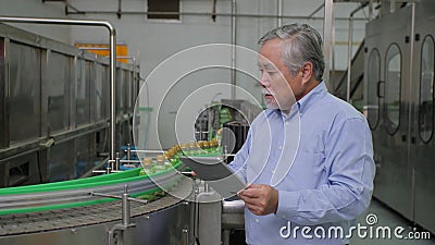 Een mannelijke fabrieksmanager in dranken verwerkende industrie die de kwaliteit van het product controleren stock footage Een mannelijke fabrieksmanager in dranken verwerkende industrie die de kwaliteit van het product controleren stock footage