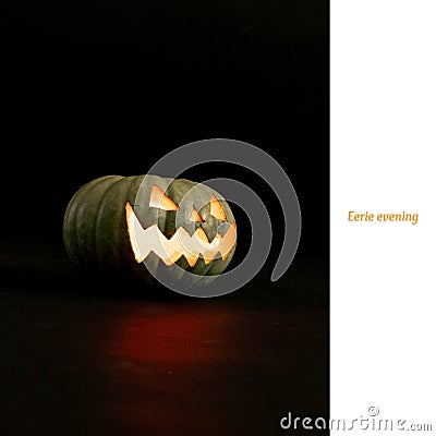 Eerie evening text on white and carved jack o lantern halloween pumpkin on black background Stock Photo