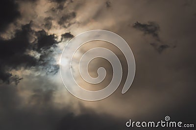 An eerie scene of cloudy sky that covers the sun little and creates some anxiety and expectation of something bad in Stock Photo