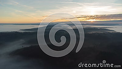 Eerie scenery of beautiful sunrise above clouds over misty mountains Stock Photo