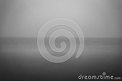 Eery photo of calm lake with snow and foggy sky Stock Photo