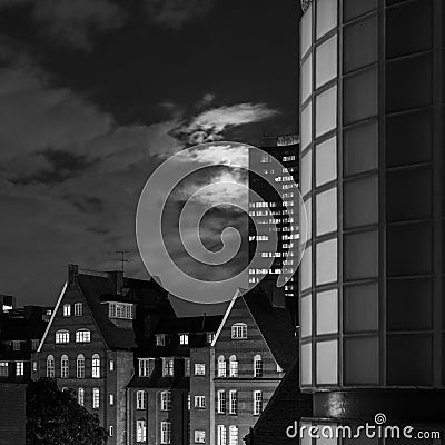 Eery view of moonlit clouds over old redbrick building at night Stock Photo