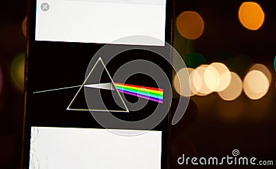 Pink Floyd`s Dark Side of the Moon disc on a mobile phone with defocused Bokeh effect background Editorial Stock Photo