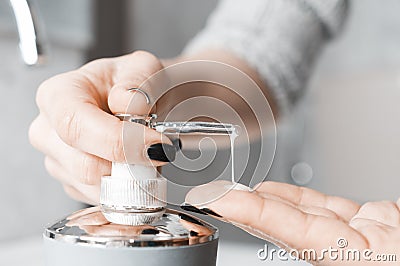 Effective handwashing techniques: Woman soaping her hands through a soap dispenser. Hand washing is very important to avoid the Stock Photo