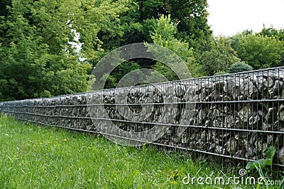 An effective, quick to install wall made of gabions. In the park Stock Photo