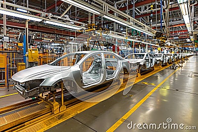 Efficient modern car assembly line in a busy factory setting for optimized mass production Stock Photo