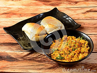 Egg bhurji with Pav is a spicy egg curry dish made up of eggs, onion, tomatoes and indian spices served with buns or pav, isolated Stock Photo