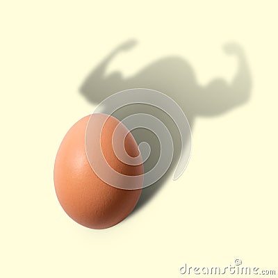 The egg casts a shadow in the form of a bodybuilder. Stock Photo