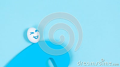 An egg with a cheerful expression rushing on a wave of good luck. The concept of a successful life position of an optimist. Blue Stock Photo