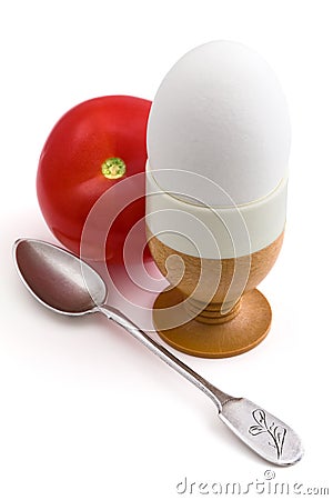 Egg in eggcup, a teaspoon and tomato Stock Photo