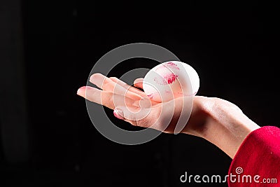 Egg in hand. Imprint of the lips, womens lipstick on the egg. Oral sex, blowjob. Reproduction. Male testicles, sperm Stock Photo