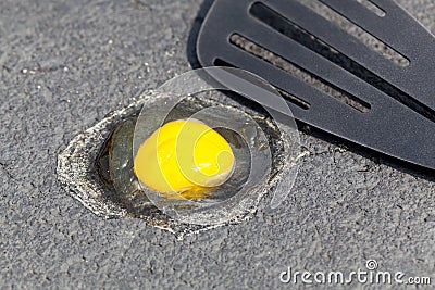 Egg on hot road surface beginning to fry Stock Photo