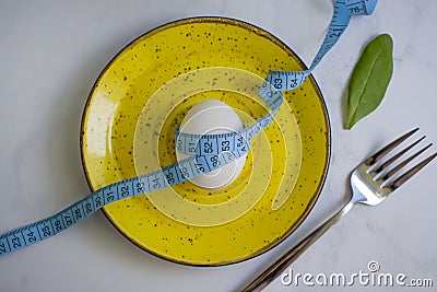 Egg, measuring tape, lettuce leaf in a plate Stock Photo