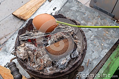 Cooking skewer egg on an old, vintage wood stove, in flames Stock Photo
