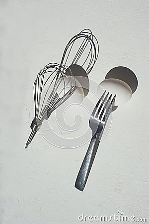 Egg with shadow from the fork. Minimalism. Cooking pastries, omelets. Easy. Whisk for whipping. Stock Photo
