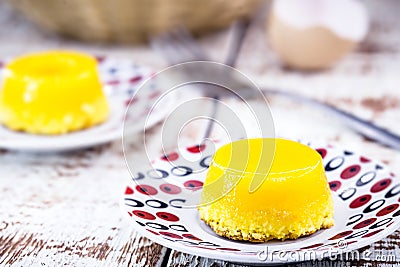 Egg yolk candy, called Quindim in Brazil, and Portugal in brisa-do-Lis. Sweet dessert on rustic wooden background Stock Photo