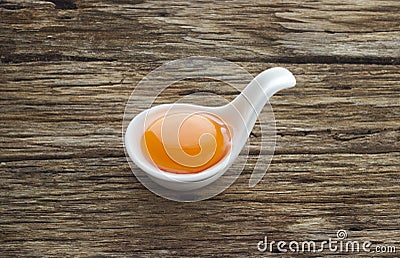 Egg yolk in the modern spoon on table wooden Stock Photo