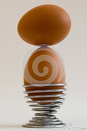 Eggs balancing in eggcup Stock Photo