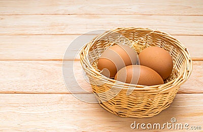 Eggs in the basket on pine wood table with coppy apace Stock Photo