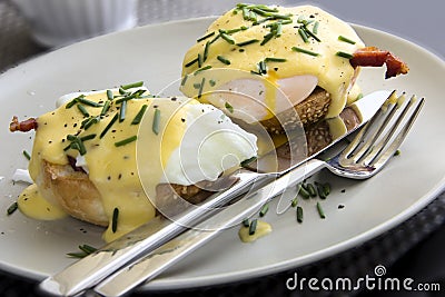 Eggs Benedict dish consisting of poached eggs and sliced ham on toasted muffins Stock Photo