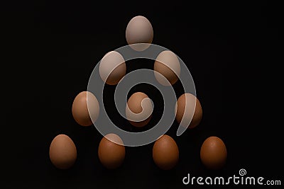 Eggs of different shades on a black background like a pyramide Stock Photo
