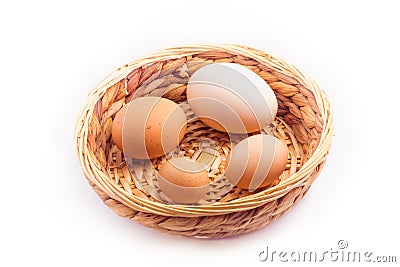 eggs - four chicken eggs of different sizes in a small wicker basket Stock Photo