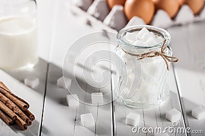 Eggs, milk, cinnamon, white sugar on wooden table Stock Photo