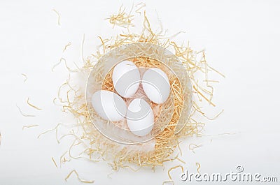 Eggs in a nest of hay on a white background. Concept easter composition, spring holiday, healthy food. Top view, flat Stock Photo