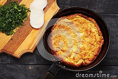 Eggs omelet, herbs and onions on a table Stock Photo