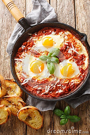 Eggs in Purgatory is an easy Italian dish served with lots of crusty bread for dipping closeup. Vertical top view Stock Photo