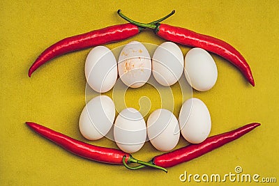 Eggs and red pepper in the form of a mouth with teeth. One of the teeth is sick in the form of a cracked egg. Sick tooth Stock Photo