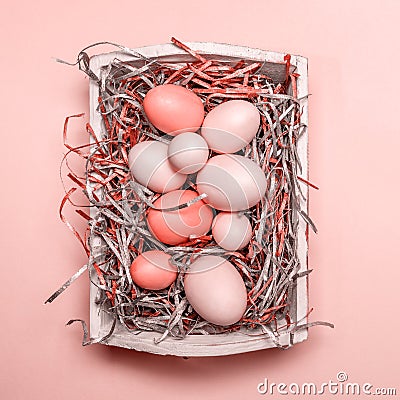 Eggs in a white tray. Creative Easter concept. Modern solid pink background. . Living coral theme - color of the year 2019 Stock Photo