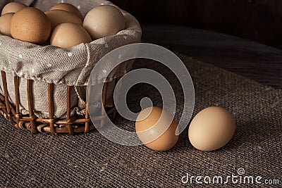 Eggs in a wicker basket on a wooden table Stock Photo