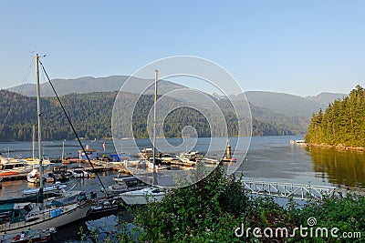 A marina full of boats surrounded by a beautiful calm ocean and forested shores, outside Egmont on the Sunshine Coast Editorial Stock Photo