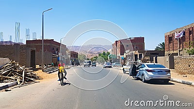 Egypt, Dahab - June 20, 2019: an Arab riding a bicycle along one of the streets of Dahab. Desert Street. Egyptian residential Editorial Stock Photo