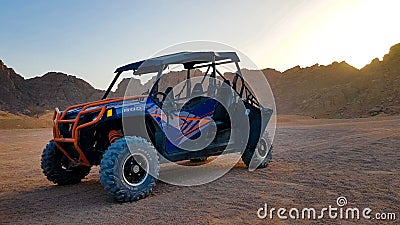 Egypt, Sharm El Sheikh - June 07, 2019: A blue buggy stands in the desert amid mountains at sunset without people Editorial Stock Photo