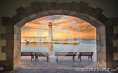 The Egyptian lighthouse at the old harbor of Rethimno through a frame of an arched door, Crete. Stock Photo