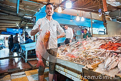 Egyptian seller showing big fresh fish Editorial Stock Photo