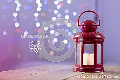 Eid al-Fitr Mubarak Greeting Typography with Bokeh backgound. Arabic lantern on wooden backgound Stock Photo