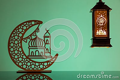 Eid Mubarak concepts with lamp inscribed with arabic text translated to english as Ramadhan is our light., with crescent Stock Photo