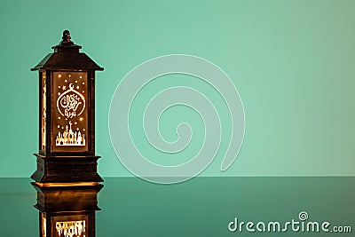 Eid Mubarak concepts with lamp inscribed with arabic text translated to english as Ramadhan is our light. Stock Photo