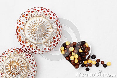 Eid Mubarak greeting with Eid Al Adha sacrifice festival, Islamic Arabic candle and sweet chocolate sugars Stock Photo