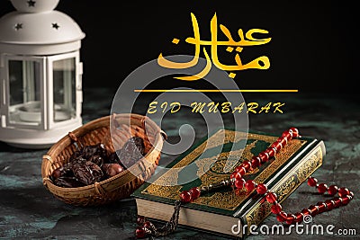 Eid Mubarak wordings in Arabic with the Holy Qoran. Stock Photo