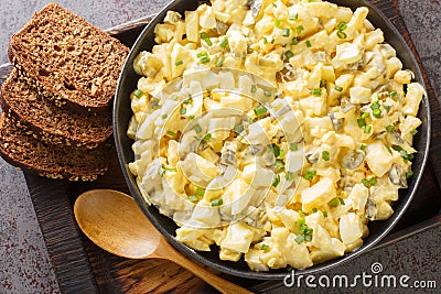 Eiersalat is a creamy German egg salad with cubes of crisp apple and crunchy sour pickles. closeup on the wooden board. Horizontal Stock Photo