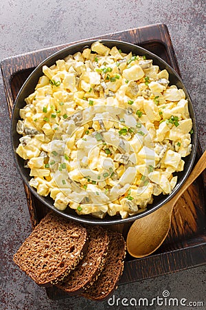 Eiersalat German Egg and Apple Salad served with bread closeup on the wooden board. Vertical top view Stock Photo