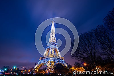 Eiffel Tower brightly illuminated at dusk Editorial Stock Photo