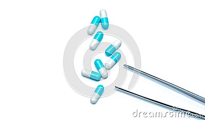 Eight blue-white capsules with stainless steel forcep isolated on white background. Colorful capsule pills. Pharmacy products. Stock Photo