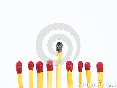 Eight fresh match sticks with one used match aligned in a row and over a white background Stock Photo